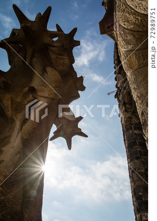 スペインバルセロナのサグラダファミリアの窓から見える建物の彫刻とまぐしい太陽の写真素材