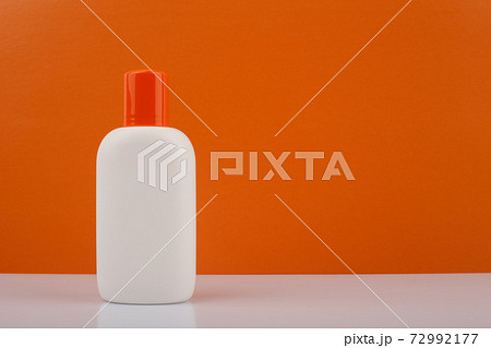 Sunscreen lotion against orange background with space for text Sunscreen lotion against orange background with space for text 72992177