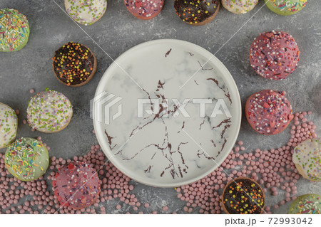 Colorful sweet small doughnuts with sprinkles and a cup of tea 72993042