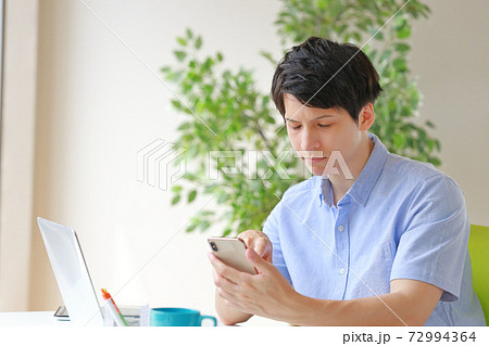 スマホを持ちあきらめた表情のビジネスマン 72994364