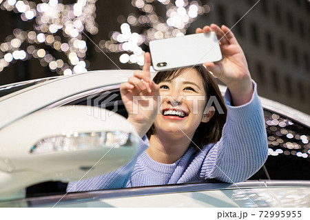 イルミネーションを撮影する若い女性 72995955