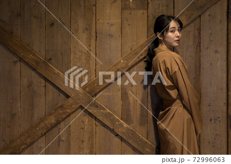 壁に寄りかかる女性の写真素材