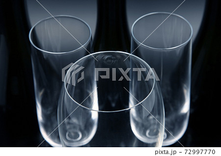 Three empty wine bottles and three empty wine glasses Three empty wine bottles and three empty wine glasses 72997770