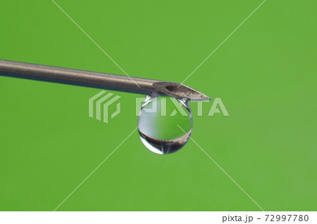 drop of medicine on the tip of a medical injection needle 72997780