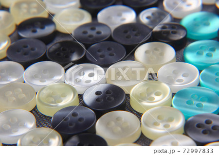Plastic shiny buttons for clothes on a fabric background. Fashion and clothing. Factory industry. 72997833