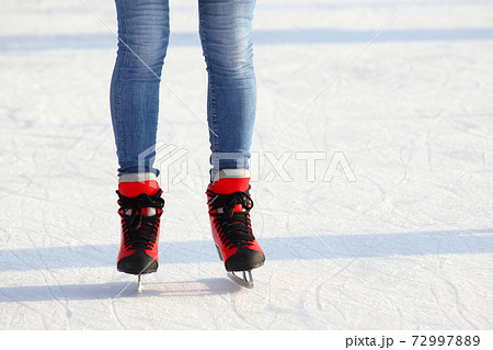 Female legs in skates on an ice rink 72997889
