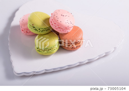 Two pink macaroons with poppy seeds on a Two pink macaroons with poppy seeds on a 73005104