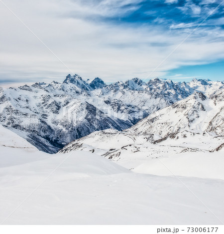 Snowy blue mountains in clouds 73006177