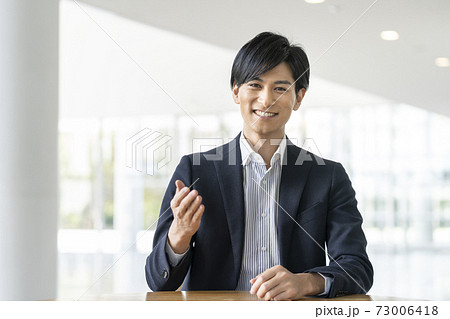 カメラ目線で話す30代のビジネスマン カメラ目線で話す30代のビジネスマン 73006418