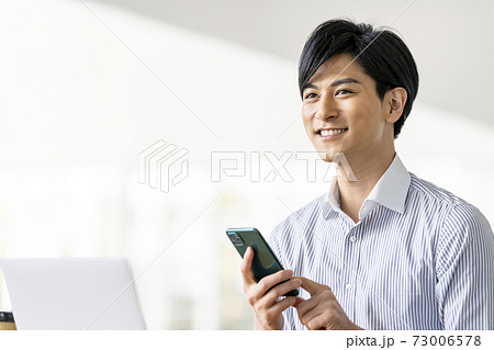 スマートフォンを操作する若い男性 73006578