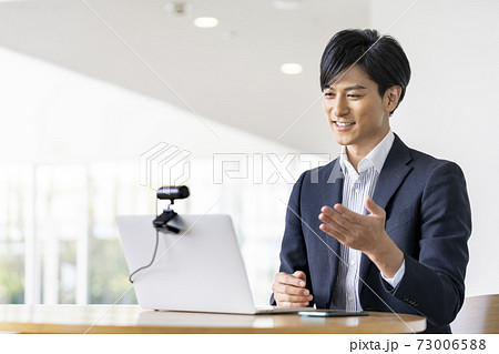 ウェブカメラに向かって話すビジネスマン　ビデオ通話　オンライン会議　イメージ 73006588