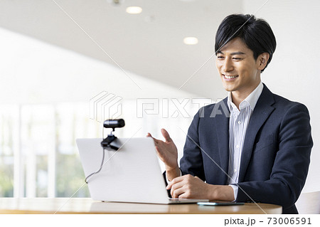 ウェブカメラに向かって話す若い男性　ビデオ通話　オンライン会議　イメージ 73006591