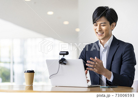 ウェブカメラに向かって話す若いビジネスマン　ビデオ通話　オンライン会議　イメージ 73006593