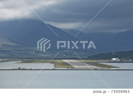 View from the end of runway at Akureyri airport in Iceland. A small plane is taking off View from the end of runway at Akureyri airport in Iceland. A small plane is taking off 73009963