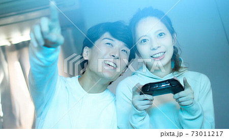 部屋でテレビゲームを楽しむ若い男女 部屋でテレビゲームを楽しむ若い男女 73011217