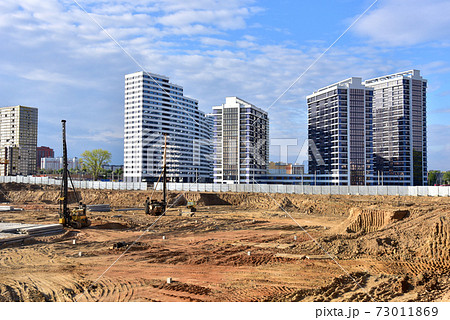 Construction site with machinery for deep foundation piling. Vibrating hydraulic hammer. Construction site with machinery for deep foundation piling. Vibrating hydraulic hammer. 73011869