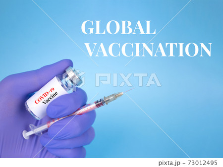 Doctor or scientist holding vial dose of COVID-19 vaccine with syringe against blue background with copy space - prevention coronavirus, global vaccination concept. Selective focus 73012495