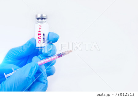 Doctor or scientist holding vial dose of COVID-19 vaccine with syringe against white background with copy space - prevention coronavirus, global vaccination concept. Selective focus Doctor or scientist holding vial dose of COVID-19 vaccine with syringe against white background with copy space - prevention coronavirus, global vaccination concept. Selective focus 73012513