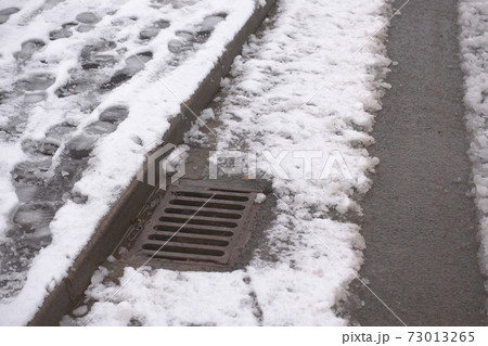 3 - Thawing snow flows into this kerbside drain. Pavement footsteps. 3 - Thawing snow flows into this kerbside drain. Pavement footsteps. 73013265