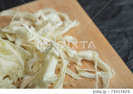 Chopped white cabbage on the wooden cutting board Chopped white cabbage on the wooden cutting board 73013829
