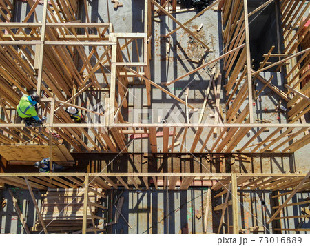 Aerial view of a new building being framed by carpenters. Aerial view of a new building being framed by carpenters. 73016889