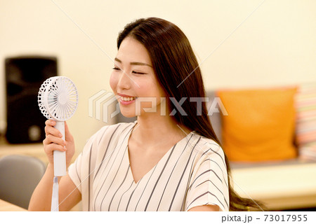 携帯扇風機を持つ女性 携帯扇風機を持つ女性 73017955