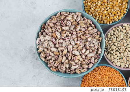 Bunch of various uncooked beans, corns and red lentils on marble surface 73018193