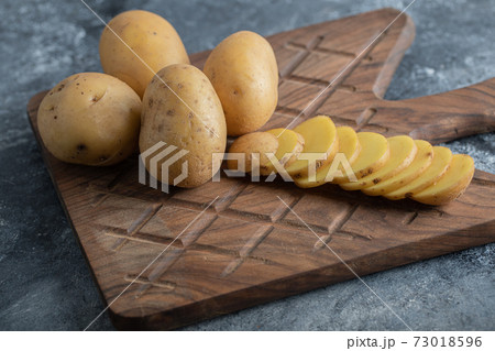 Close up photo of organic potatoes on wooden cutting board Close up photo of organic potatoes on wooden cutting board 73018596