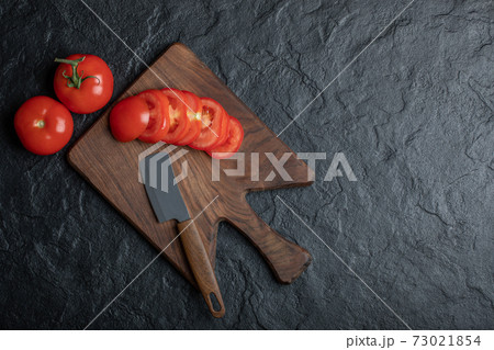 High angle view of freshly picked, juicy tomatoes on dark stone background 73021854