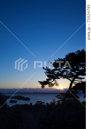 朝日が照らす冬の太平洋と雪景色の松島 宮城県の写真素材