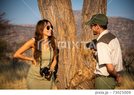 Close-up of brunette laughing with safari guide Close-up of brunette laughing with safari guide 73025009