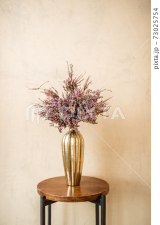 Dried Calluna flower in a gold vase 73025754