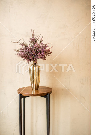 Dried Calluna flower in a gold vase Dried Calluna flower in a gold vase 73025756