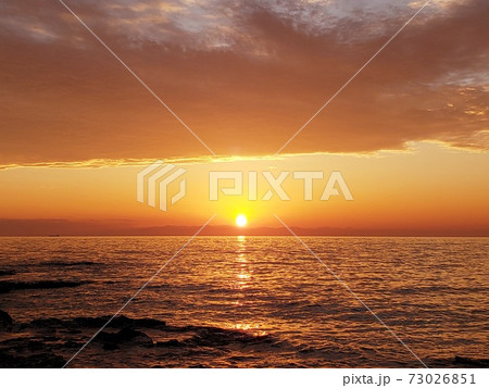 愛知県美浜町の野間埼灯台から眺める紀伊半島に沈んでいく夕陽と茜色に染まる伊勢湾【12月】 73026851