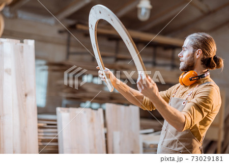 Carpenter with some wooden part at the workshop Carpenter with some wooden part at the workshop 73029181