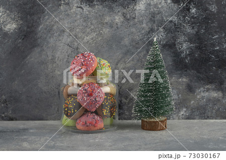 Colorful sweet doughnuts with Christmas tree toy 73030167