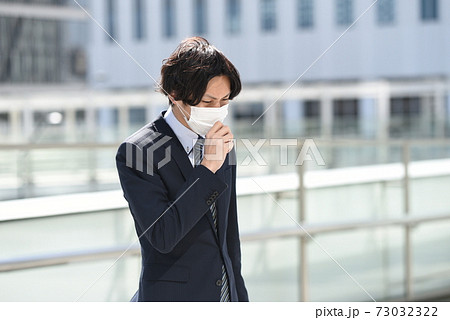 スーツを着たマスク姿のビジネスマンの男性 73032322