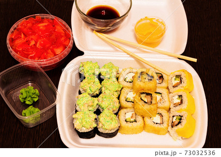 A set of ready-made sushi and rolls and ingredients for them. 73032536