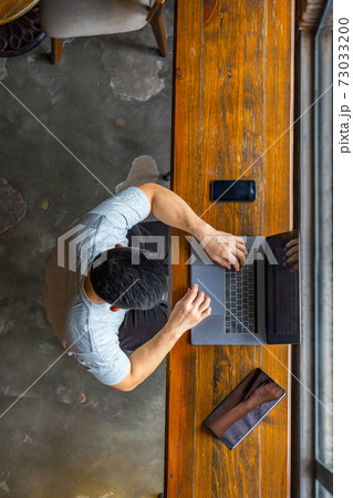 Top view of Asian freelancer using laptop on wooden table Top view of Asian freelancer using laptop on wooden table 73033200