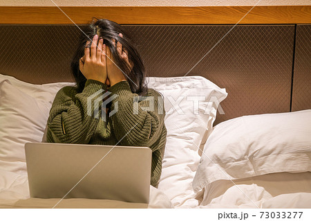 Asian woman feel headache and tired after working on laptop 73033277