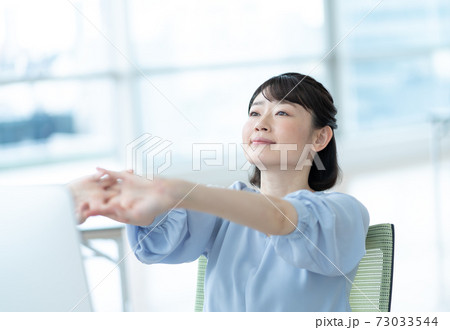 オフィスで伸びをする女性 73033544