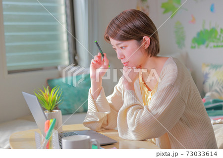 テレワーク_ペンを持ち明るい表情で考える女性 テレワーク_ペンを持ち明るい表情で考える女性 73033614