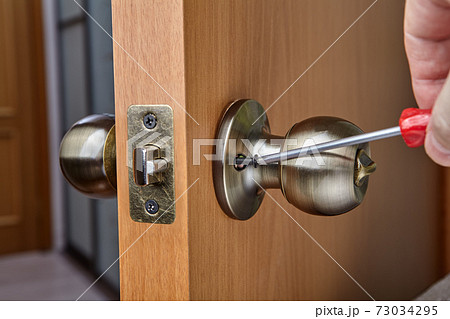 Mounting brass doorknob with exposed set-screw, close-up. Mounting brass doorknob with exposed set-screw, close-up. 73034295