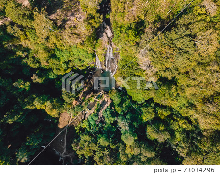 Waterfall with small lake in tropical jungle at Bali. Indonesia. Aerial drone view 73034296