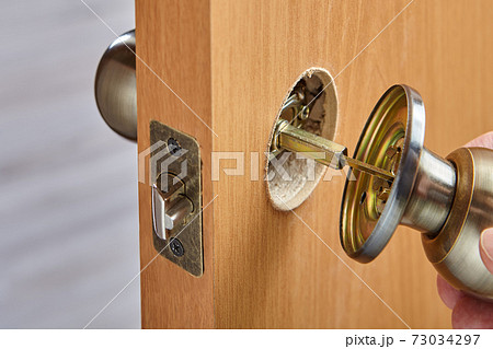 Installing a new brass handle in face bore of interior door. The spindle connects the doorknob parts. 73034297