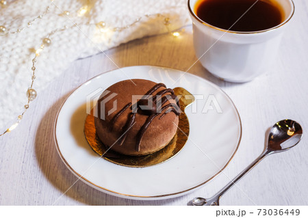 Contemporary chocolate mini mousse cakes with cream insert, covered with chocolate velvet spray and chocolate gourmet glaze, decorated with whipped chocolate ganache 73036449