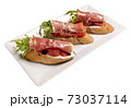 Bruschettes with jamon and grapefruit. Isolated image on white background. 73037114