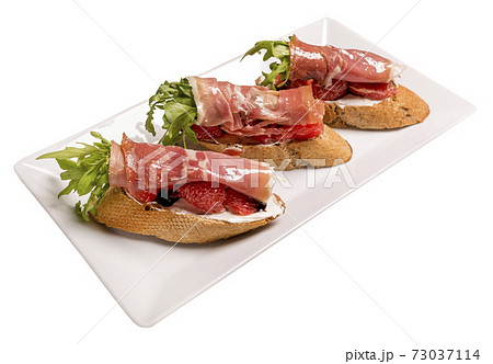 Bruschettes with jamon and grapefruit. Isolated image on white background. 73037114