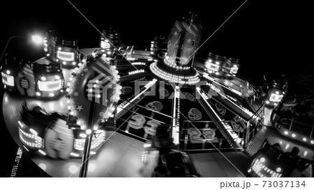 Carousels at amusement fair at night in black and white Carousels at amusement fair at night in black and white 73037134