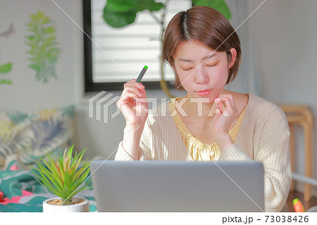 テレワーク_ペンを持ち_目を閉じて考える女性 73038426